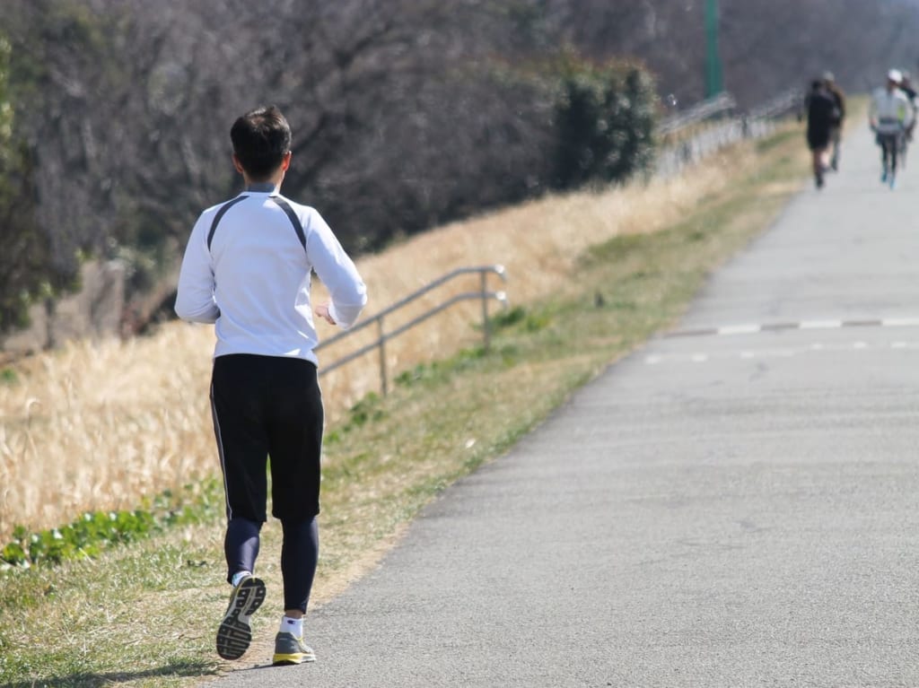 ぱくたそ河川敷を走るランナーの写真素材