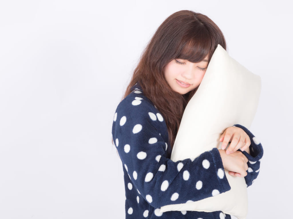 ぱくたそフリー素材「まくらを抱いて爆睡中」